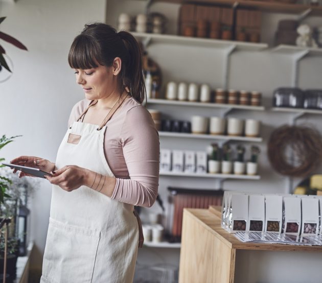 Florist working with a digital tablet in her flower shop